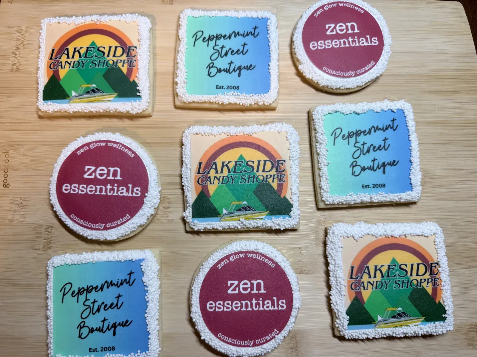 Nine square and round cookies printed with client business logos, including Lakeside Candy Shoppe, Peppermint Street Boutique, and Zen Essentials, edged in white nonpareils.